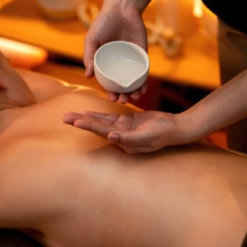 Masseur hands pouring aroma oil on woman back. Masseuse prepare oil massage procedure for customer at spa salon in luxury resort. Aroma oil body massage therapy concept. Quiescent